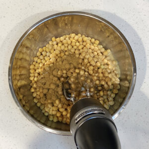 Hand blender mixing hummus ingredients